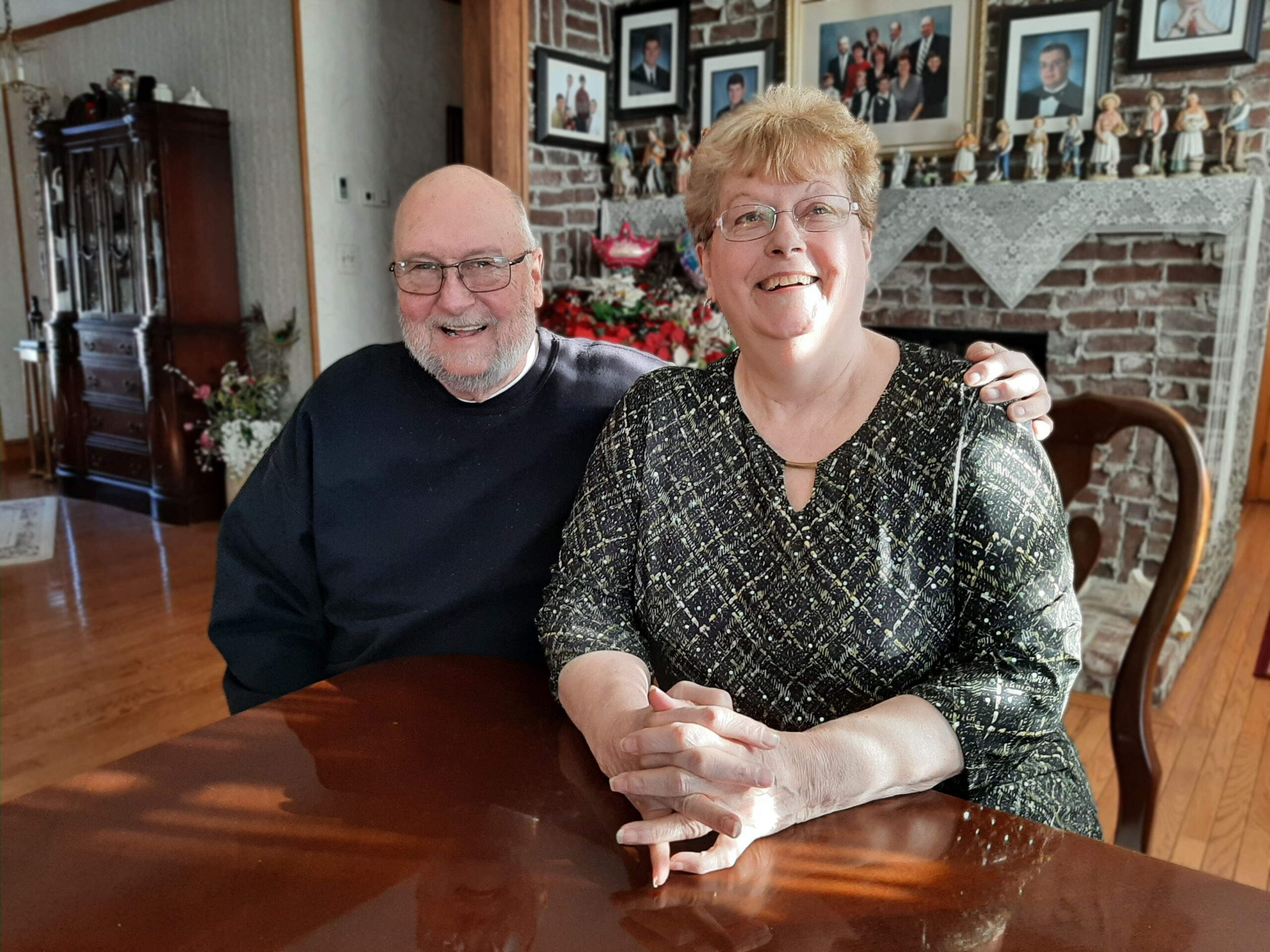 a man and a woman sit at a table smiling